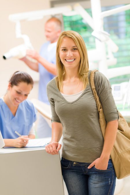 smiling woman at dental office front desk